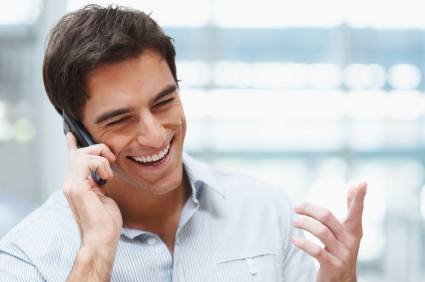 Laughing young guy enjoying a conversation over the cellphone